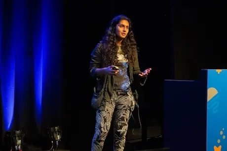 A woman on stage speaking.