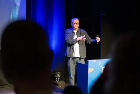 A man on stage speaking.