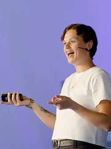Marley on stage smiling and talking with a clicker in hand.